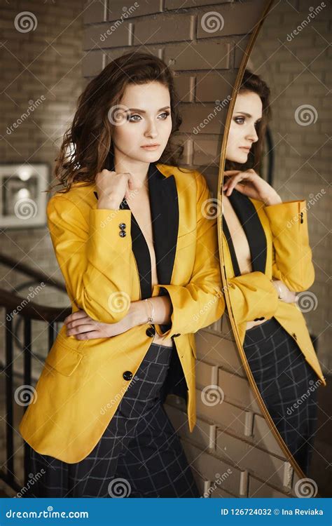 Fashionable And Brunette Model Girl With Gentle Makeup In The Stylish Gold Jacket And In A