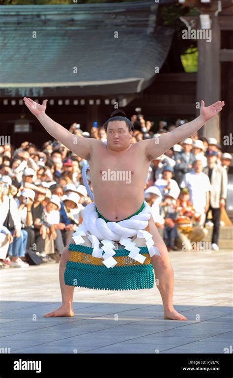 Mongolian sumo wrestler Hakuho, wearing a grand champion's ceremonial rope belt, performs a ...