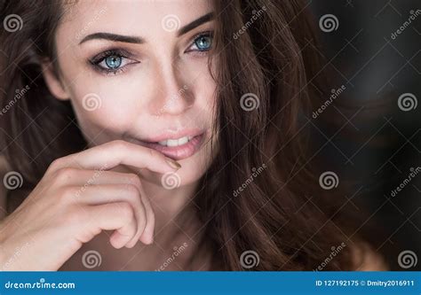 Close Up Portrait Of An Attractive Young Woman Touching Her Lips By