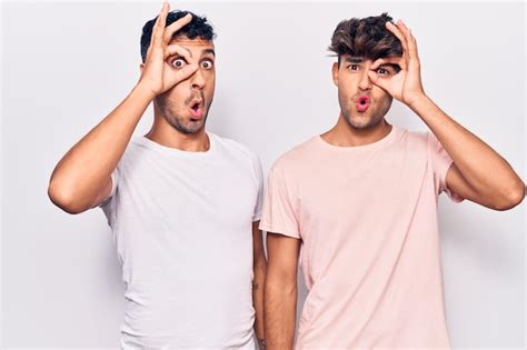 Jeune couple gay portant des vêtements décontractés faisant un geste correct choqué par le