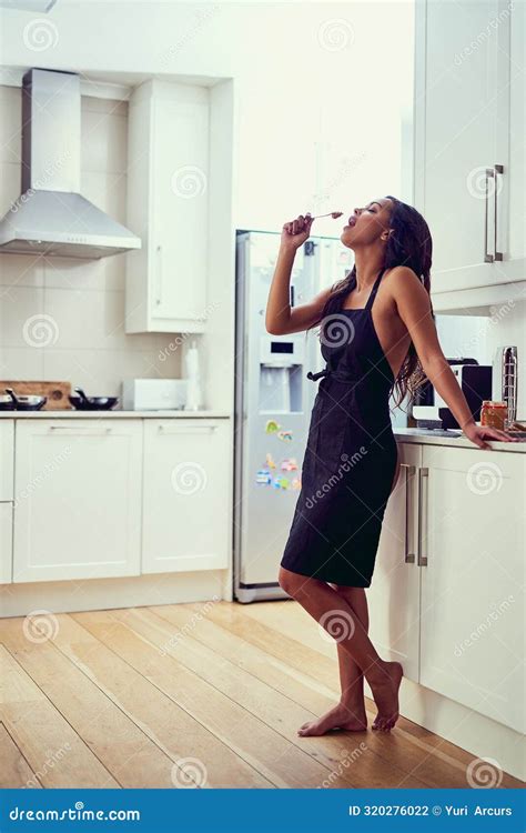 Woman Sensual And Kitchen Eating Snack Off Spoon With Apron On For Sexy Hungry And Morning