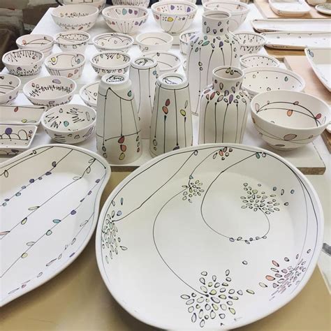 A Table Topped With Lots Of White Plates And Bowls Filled With Designs