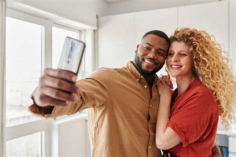 Diverse Couple Taking Selfies At Home By Stocksy Contributor Ivan