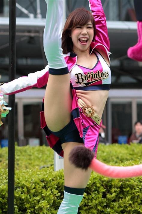 A Woman In Pink And Black Outfit Doing A Handstand On Top Of A Pole