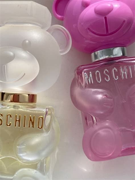 two pink and one white teddy bears next to each other with perfume ...