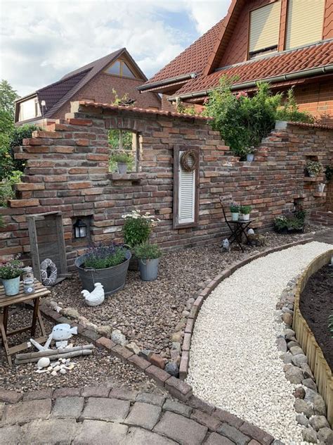 A Brick House With Potted Plants In The Front Yard