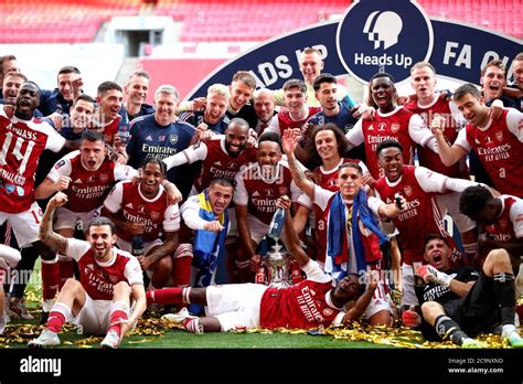 Arsenal players and staff celebrate with the trophy after winning the ...