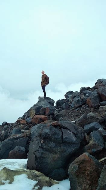 Premium Photo Tourist Stands On Rocks In The Mountains