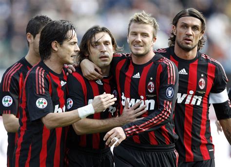 Three Soccer Players Are Hugging Each Other On The Field