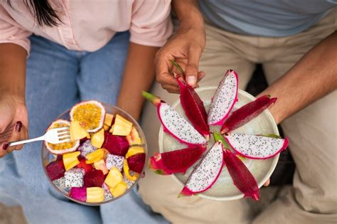 Casal comendo fruta do dragão juntos ao ar livre Foto Grátis