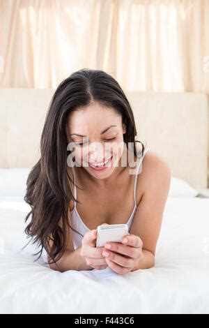 Pretty Brunette Texting On Bed Stock Photo Alamy