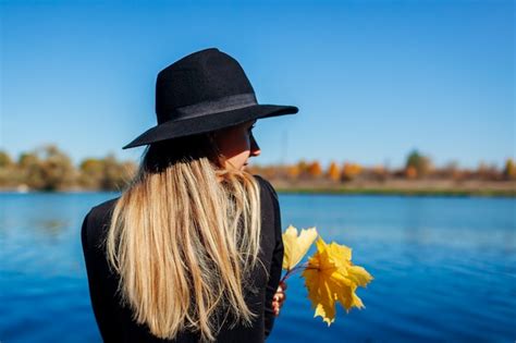 Vibraciones otoñales mujer joven que se relaja por el lago que