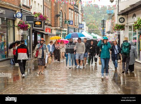 People Walking And Shopping In The Rain Under Umbrellas In The High