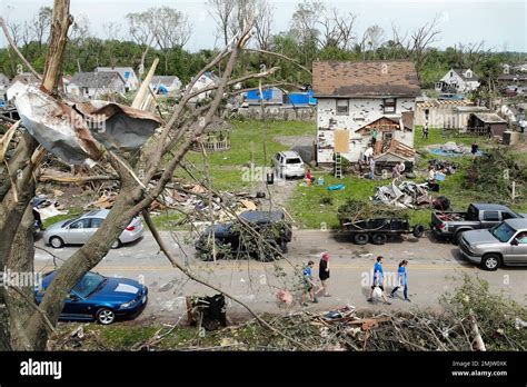 Residents Walk Through A Tornado Damaged Neighborhood Wednesday May