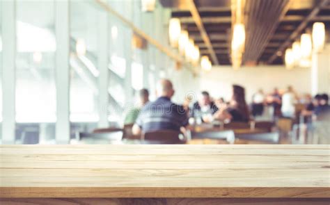 Empty Of Wood Table Top On Blurred Of People In Coffee Shop Stock Photo