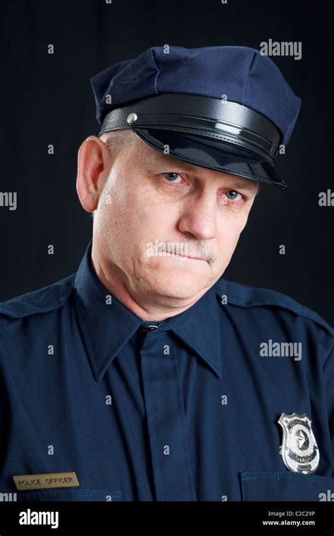 Sad police officer with a tear rolling down his face. Black background ...