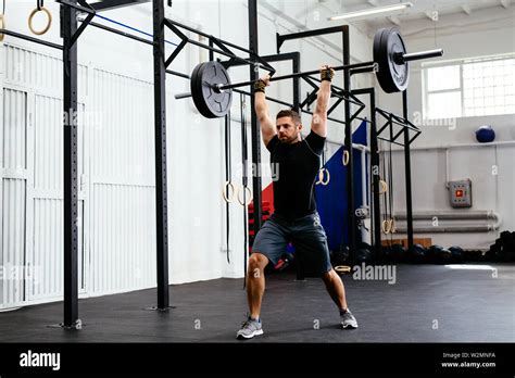 Fit Attractive Man Holding Barbell Above Head In Gym Stock Photo Alamy