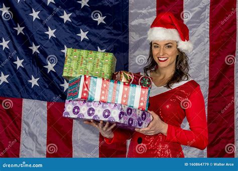 Beautiful Brunette Model Posing As An Elf With Presents Against A White