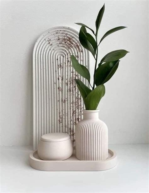 Two White Vases With Green Plants In Them On A Shelf Next To A Radiator