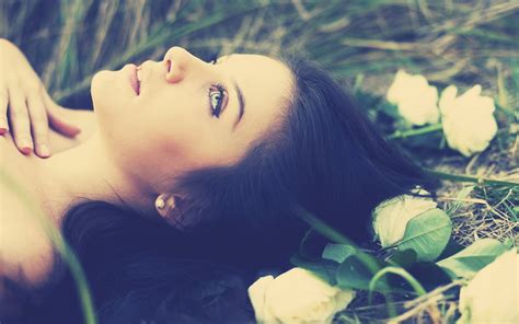 Shallow Focus On Black Haired Woman Laying On Grass Surrounded By