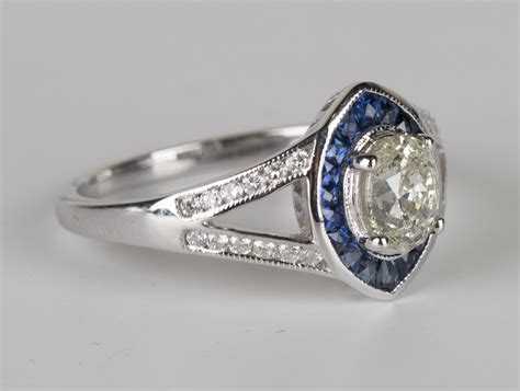 An 18ct white gold, diamond and sapphire ring, claw set with the ...