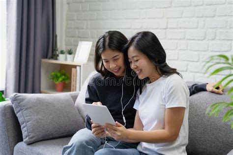 Beautiful Smiling Lgbtq Asian Lesbian Couple Listening To Their