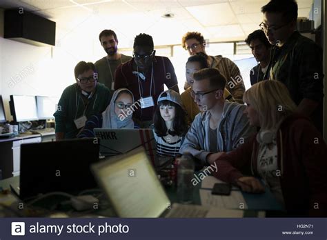 Young hacker team working hackathon at laptop in dark office Stock ...