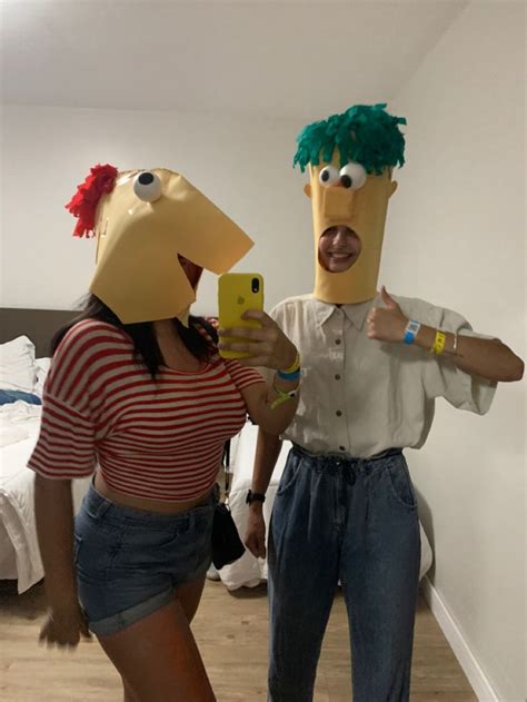 Two People In Costumes Standing Next To Each Other Holding Cell Phones