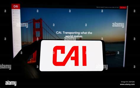 Person Holding Smartphone With Logo Of US Logistics Company CAI