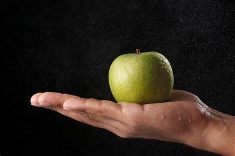 Mano Sosteniendo Una Manzana Verde Foto Premium