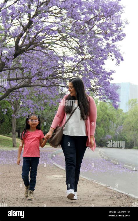 Divorced Single Mom And 4 Year Old Latina Brunette Daughter Walk Together In The Park Under The