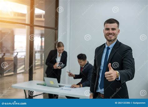 Portrait Of A Smiling Business Man And The Business Team Stock Photo