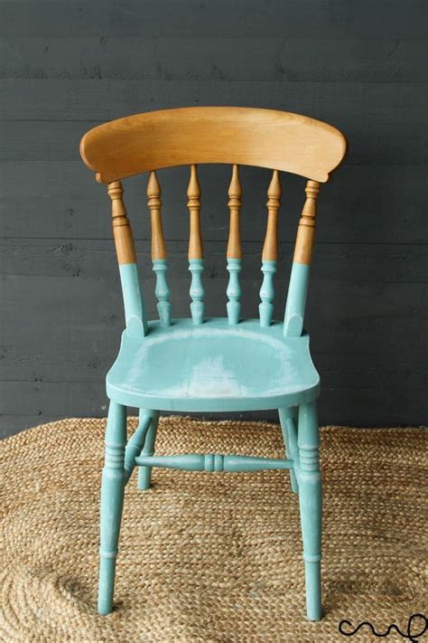 A Blue Wooden Chair Sitting On Top Of A Woven Rug Next To A Gray Wall