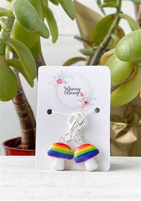 A Pair Of Earrings Sitting On Top Of A Table Next To A Potted Plant