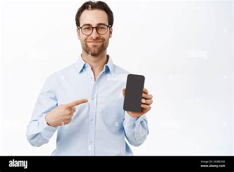 Handsome Smiling Brunette Man Pointing At His Mobile Phone Screen