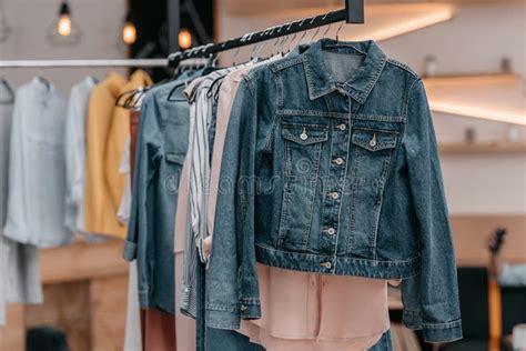 Various Stylish Clothes Hanging On Hangers In Boutique Stock Photo