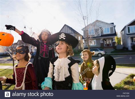 Kids In Halloween Costumes Trick Or Treating Neighborhood Stock Photo