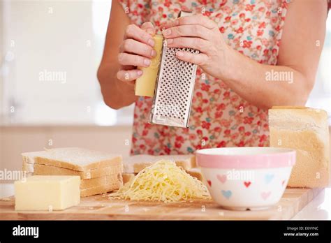 Close Up Of Woman Grating Cheese In Kitchen Stock Photo Alamy