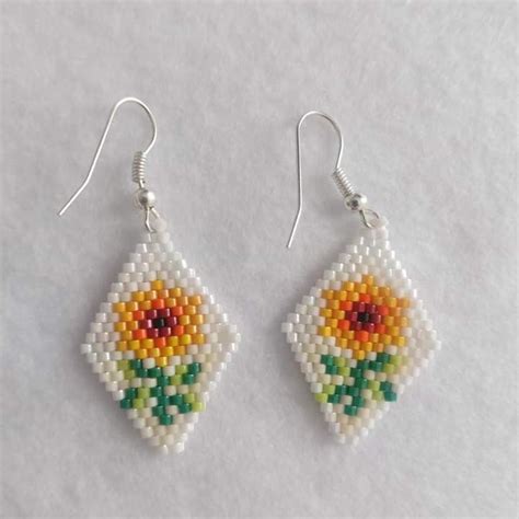 A Pair Of Beaded Earrings With Flowers On Them