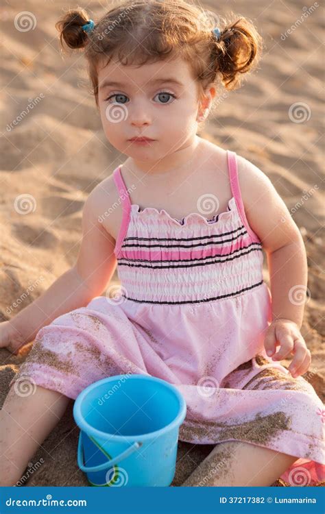 Blu Eyes Brunette Toddler Girl Playing with Sand in Beach Stock Photo ...