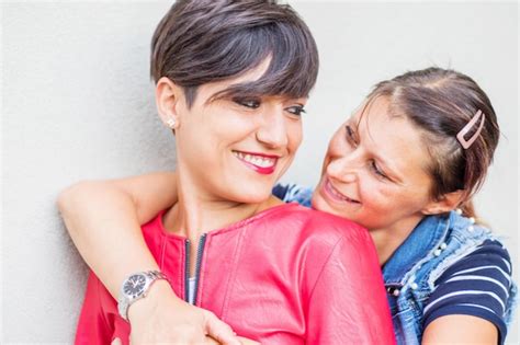 Premium Photo Smiling Lesbian Couple Embracing Against Wall