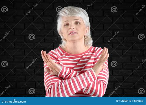 Portrait Of Mature Woman Rejecting Something On Dark Background Stock