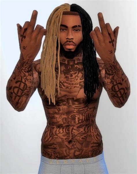 A Man With Long Dreadlocks And Tattoos On His Body Is Making The Peace Sign