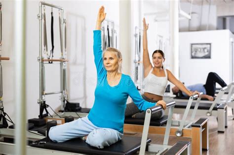 Mature Woman In Sportswear Sitting And Doing Pilates Exercises For