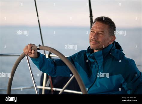 Good Looking Mature Man Sailing A Yacht And Looking Confident Stock