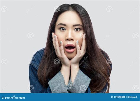 Portrait Of Shocked Beautiful Brunette Asian Young Woman In Blue Denim