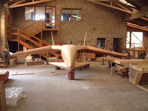 an airplane being built in a building with lots of work on the floor ...