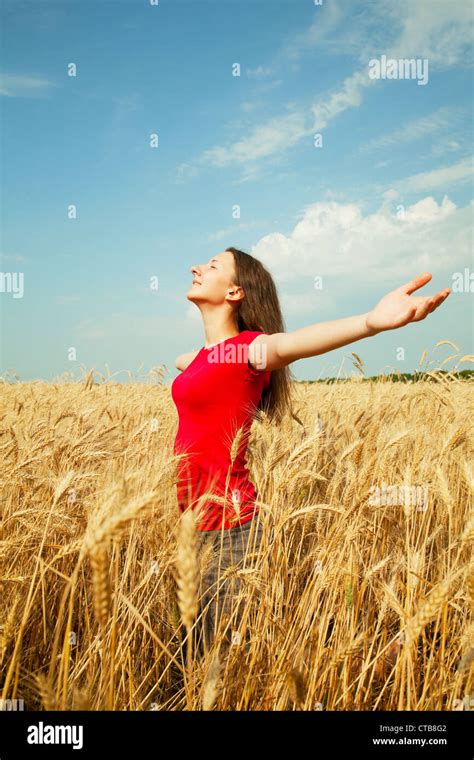 Teen Girl Staying At A Wheat Field With Her Arms Outstretched Stock