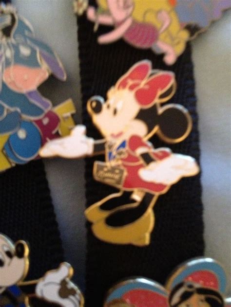 Several Mickey Mouse Pins Are Laying On Top Of A Black Belt With Other Disney Characters In The