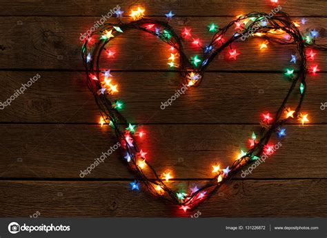 Heart from christmas lights on wood background — Stock Photo © Milkos #131226872